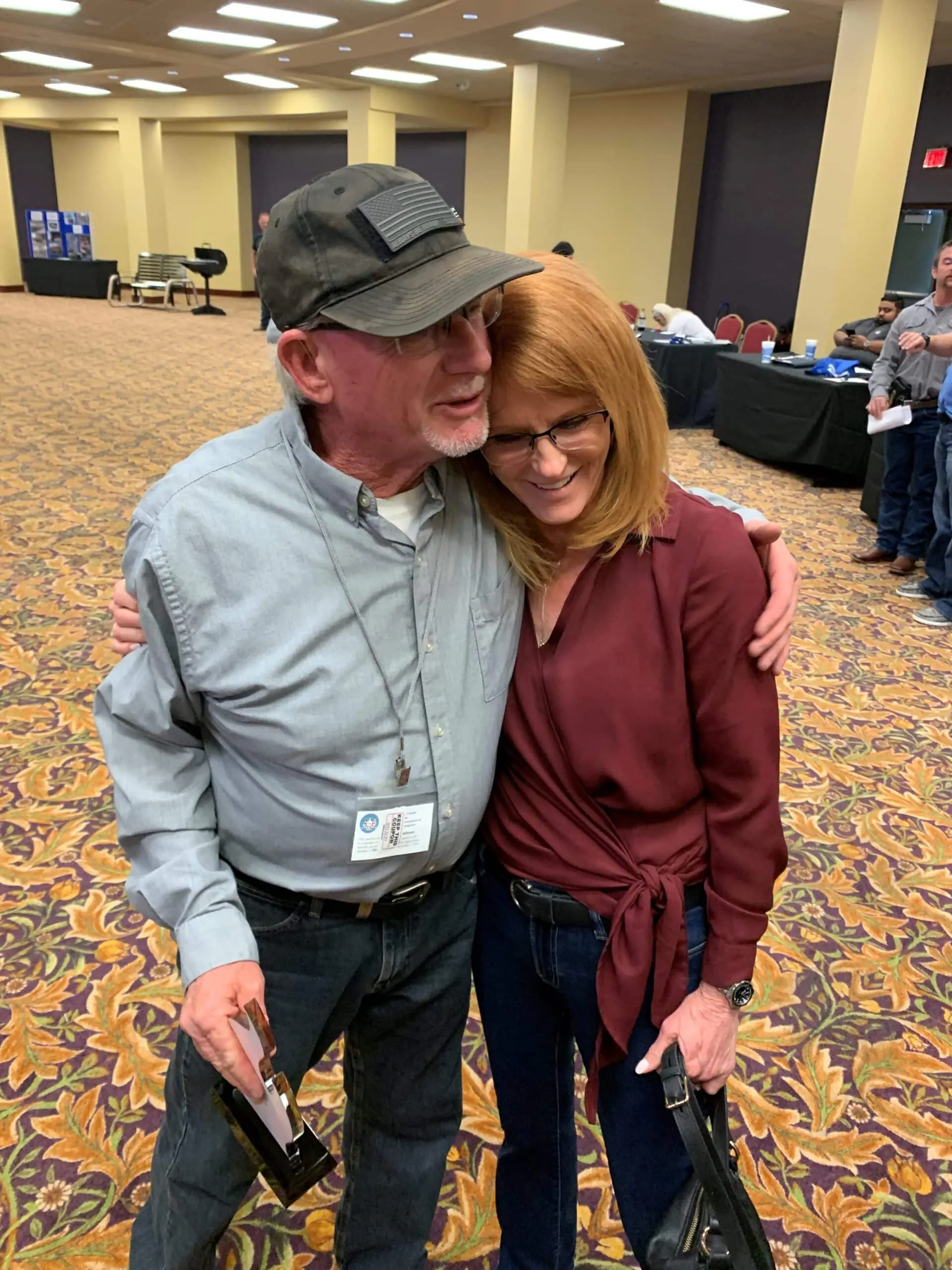 Two people hugging at an indoor event.